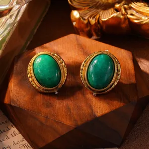 Detailansicht von grünen Vintage-Ohrringen im Hofstil mit strukturiertem Goldrahmen.