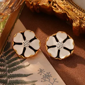 Nahaufnahme von französischen Retro-Blumenohrringen mit weißer Emaille und Gold