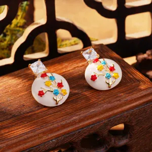 Détail de boucles d'oreilles en émail de style chinois avec motifs de fleurs