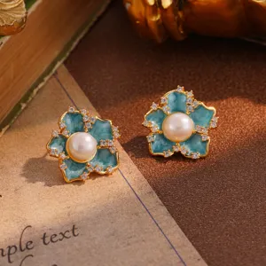 Close-up of vintage teal flower earrings with pearls and sparkling rhinestones