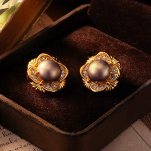 Detaillierte Nahaufnahme von Vintage-Gold-Blumenohrringen mit Perlen und glänzenden Zirkonen