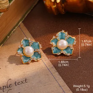 Close-up of vintage flower earrings with blue enamel, pearl, and dimension text.
