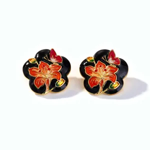 Vue détaillée de boucles d'oreilles vintage en émail avec motifs de fleurs et papillons