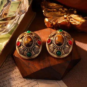 Detailopname van vintage hofstijl oorbellen met tijgeroog en gekleurde edelstenen