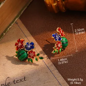 Macro detail of vintage floral stud earrings with malachite-pattern beads