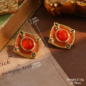 Detailed view of vintage-style gold-tone earrings with red stone and measurements