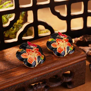 Gros plan détaillé de boucles d'oreilles en émail avec fleurs et papillons de style chinois