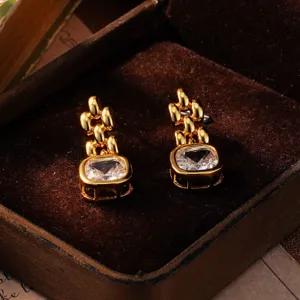 Nahaufnahme von goldenen geometrischen Ohrringen mit Zirkon in einer Schmuckschatulle