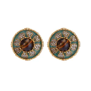 Gedetailleerd overzicht van vintage paleisstijl oorbellen met tijgeroog en groene steen