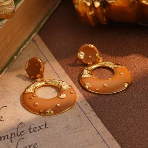 Close-up detail of vintage caramel enamel and textured gold statement hoop earrings.