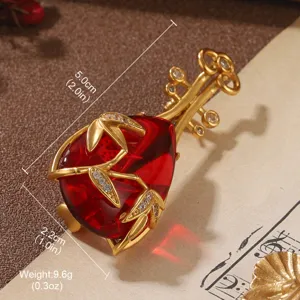 Detailed macro shot of vintage lute brooch featuring red gemstone and golden bamboo