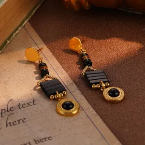 Close-up of vintage style black beads and gold tone drop earrings.