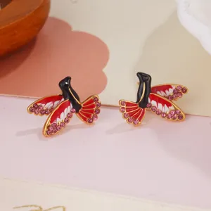 Exquisite macro detail of enamel hummingbird stud earrings with sparkling pink crystals