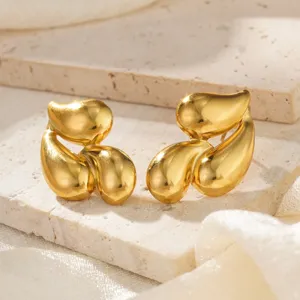 Makroaufnahme von goldenen Edelstahl-Ohrringen in organischer Wassertropfenform