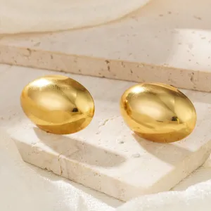 Detailansicht von glänzenden glatten goldenen ovalen Ohrsteckern aus Edelstahl auf Stein