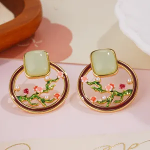 Detailed view of elegant enamel plum blossom earrings featuring pale green stones and small pearls