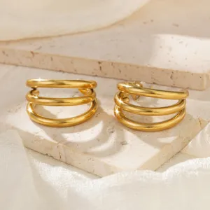 Nahaufnahme eleganter vergoldeter Edelstahl-Ohrringe mit dreifacher Schlinge