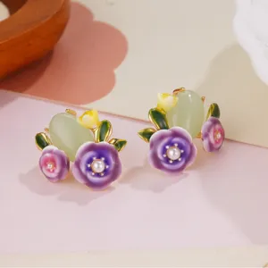 Close-up of enamel flower earrings with green jadeite and pearls.
