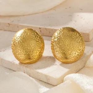 Nahaufnahme goldener Edelstahlohrringe mit Bienenwaben-Struktur in runder Form.