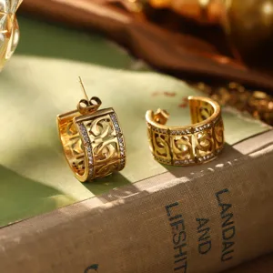Gros plan de boucles d'oreilles créoles vintage en or avec motifs creux et cristaux
