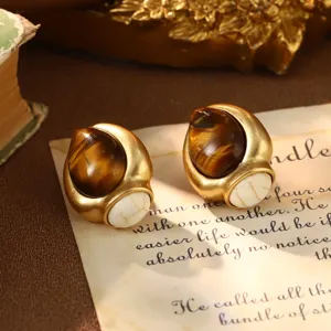Close-up of vintage French palace style earrings with tiger's eye and white stone