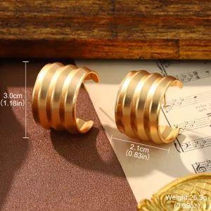 Close-up detail of vintage gold ribbed C-shaped hoop earrings showing size and weight measurements