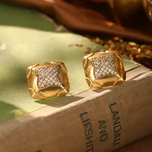 Gros plan sur des boucles d'oreilles carrées vintage en or avec cristaux pavés