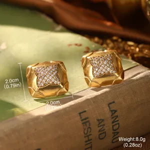 Vue macro de boucles d'oreilles carrées vintage en or avec cristaux sur un vieux livre