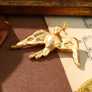 Detailed close-up shot of a palace-style vintage gold bird brooch with hammered texture