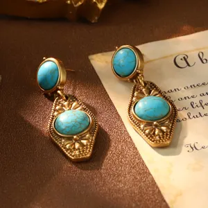 Close-up of vintage French palace style turquoise drop earrings with gold finish.