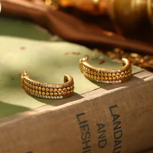 Vue détaillée de créoles vintage dorées avec perles texturées et cristaux brillants