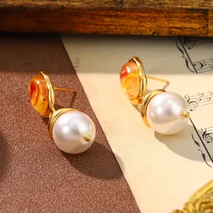 Detailed macro view of vintage court style pearl earrings with marble texture on sheet music.