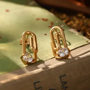 Gros plan de boucles d'oreilles trombone dorées vintage avec un zircon étincelant