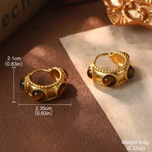 Détail de boucles d'oreilles vintage dorées avec pierre brune et mesures.