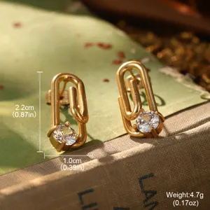 Gros plan de boucles d'oreilles trombone dorées avec cristal et dimensions détaillées