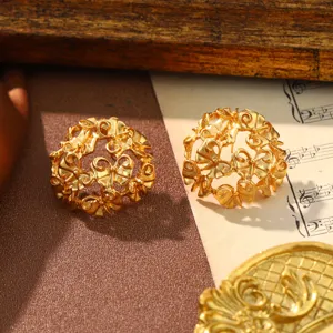 Close-up of vintage gold-tone hollow bow earrings with elegant palace style texture