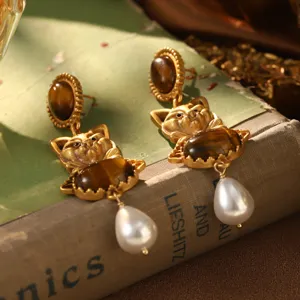 Détail macro de boucles d'oreilles chat vintage avec œil de tigre et perles