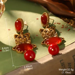 Gros plan détaillé de boucles d'oreilles chat vintage dorées avec pierres et dimensions