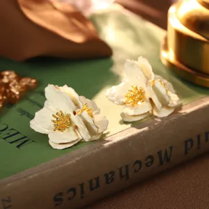 Nahaufnahme von französischen Emaille-Blumenohrsteckern im Vintage-Stil mit Golddetails.
