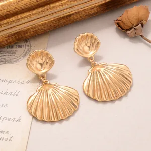 Gros plan de boucles d'oreilles vintage en forme de coquillage doré de style baroque