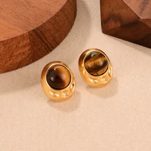 Close-up of vintage French-style oval gold earrings featuring natural tiger eye stones.
