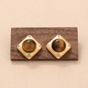 Vue macro détaillée de boucles d'oreilles dorées avec incrustation d'œil de tigre