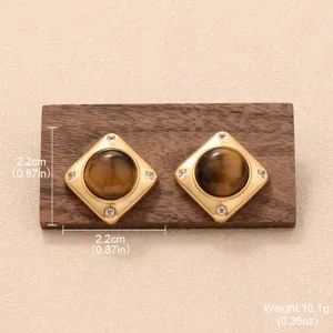 Vue détaillée de boucles d'oreilles carrées dorées avec pierre d'oeil de tigre brune