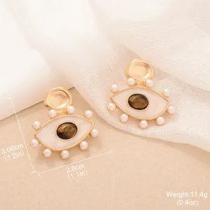Macro view of vintage eye-shaped earrings with Tiger Eye, pearls, and measurements