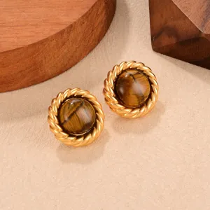 Nahaufnahme von Vintage-Tigerauge-Ohrsteckern mit gedrehtem goldfarbenem Kordelrand