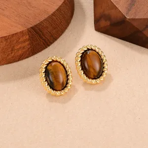 Detailed view of vintage oval tiger eye stud earrings with a gold rope frame.