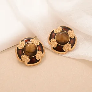 Detailed macro view of vintage tiger eye sunflower earrings with golden filigree metal accents