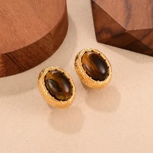 Gros plan de boucles d'oreilles vintage en œil de tigre avec monture dorée