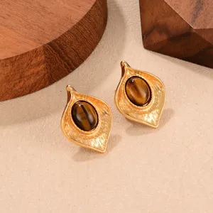 Primer plano de pendientes vintage de ojo de tigre con un detalle de diseño de hoja dorada
