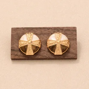 Détail de boucles d'oreilles vintage en émail marron et blanc de style Maillard